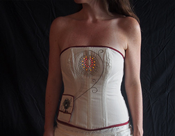 A femme wears a white corset with activated LEDs on the bust in a swirl pattern